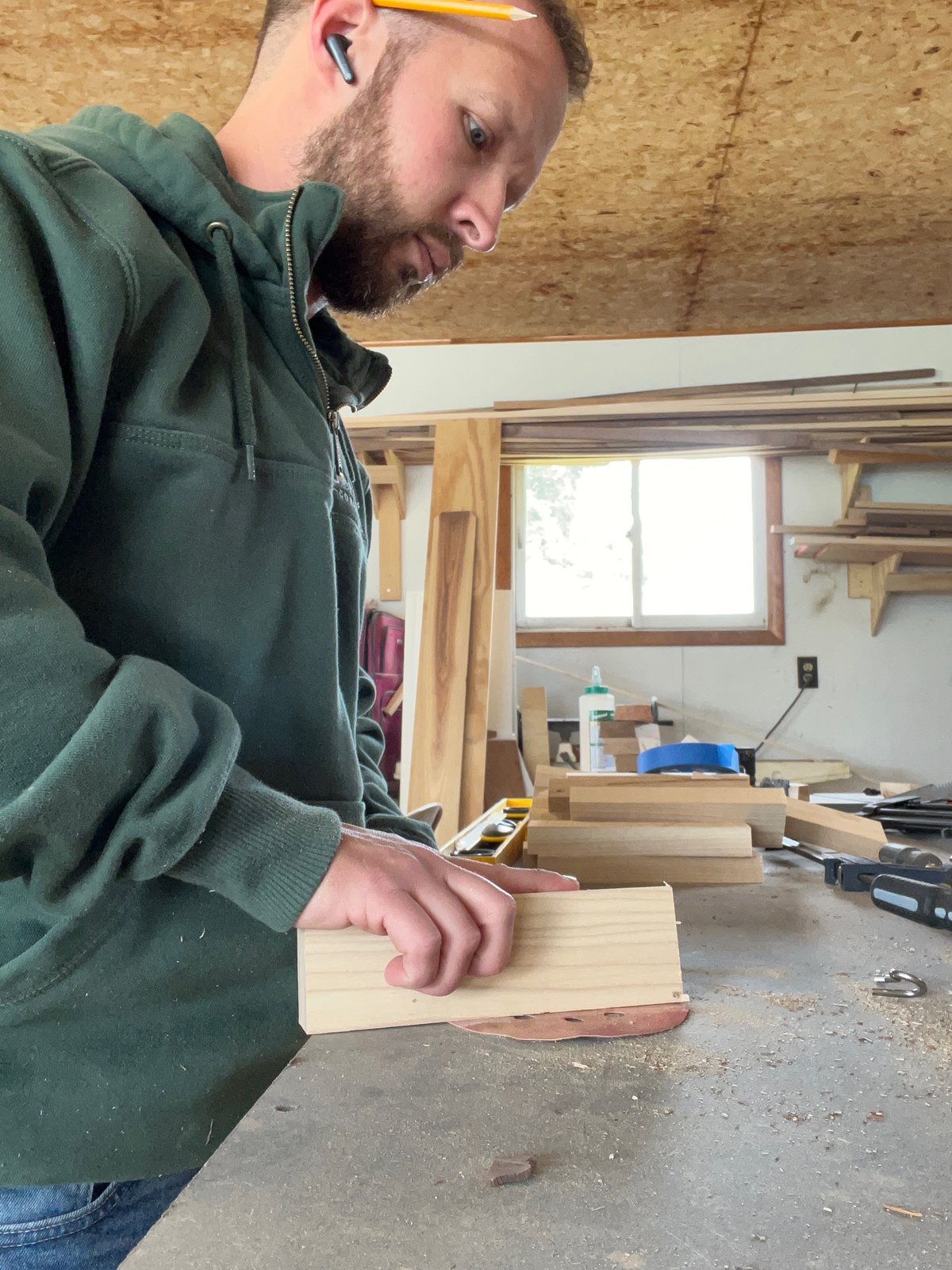 Kyle marking out a stave blank at the bench in the workshop